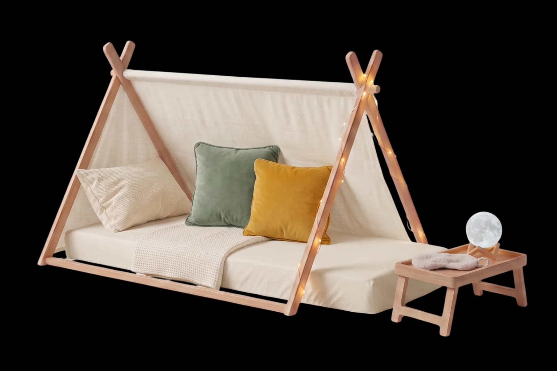 A cozy A-frame tent setup with cushions, fairy lights, a table lamp, tray table, and folded sheets and blankets.